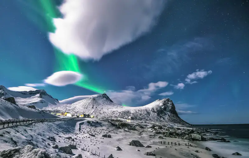 Northern lights over snowy coast
