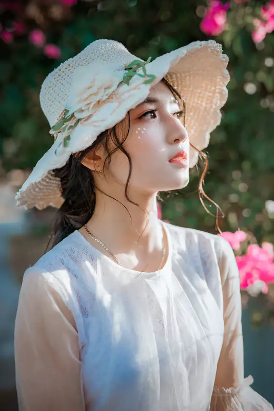 Woman in sun hat among roses