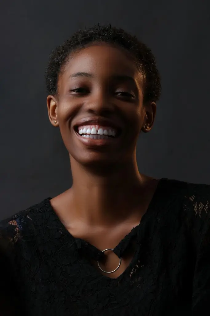 Woman smiling, dark background