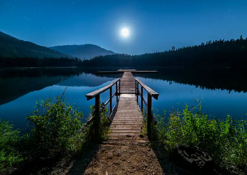 Wooden jetty on moonlit lake